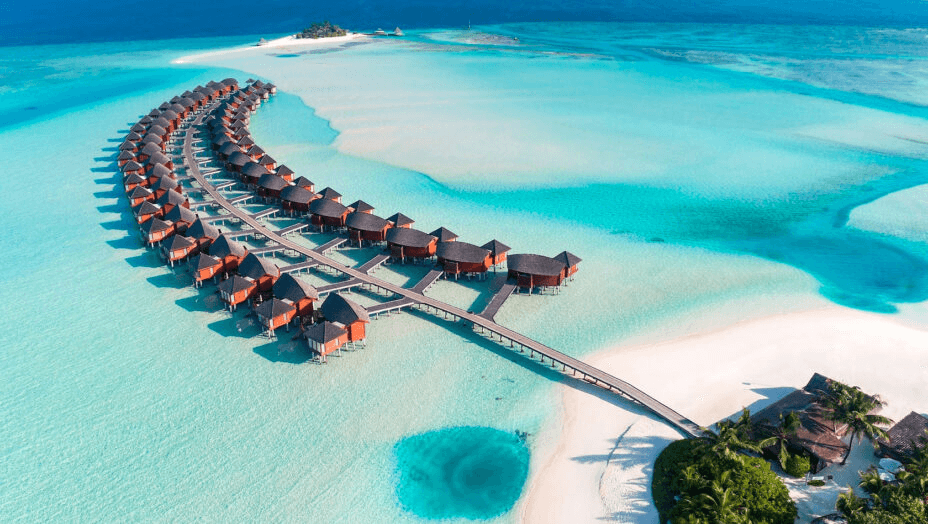 Curving line of overwater villas across a turquoise lagoon