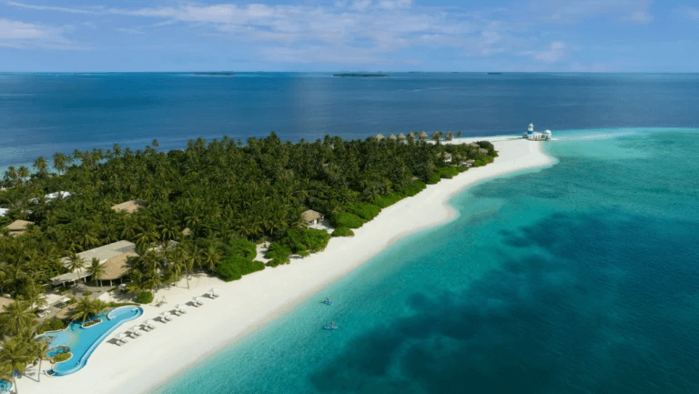 Long white beach along a forested island, seen from the air