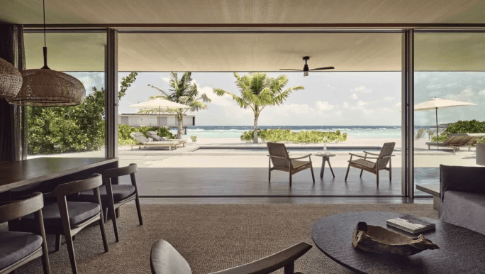 Minimalist villa living room opening onto a sunlit terrace