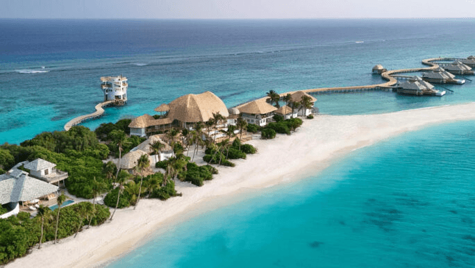 Island villas and overwater pavilions along a white beach