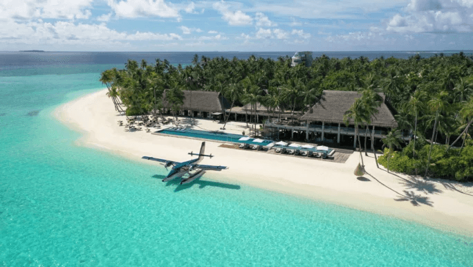 Seaplane moored in front of a beachfront pavilion