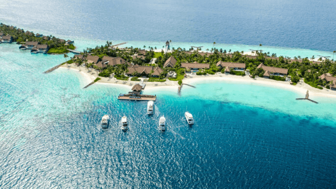 Island resort with boats at the jetty in a turquoise lagoon