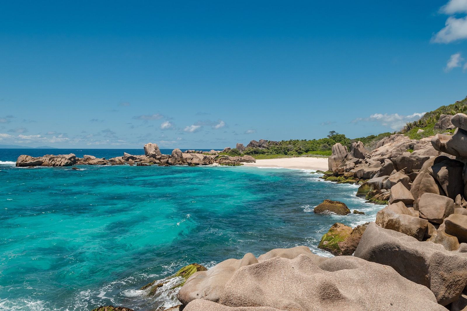 Granite boulders beside clear turquoise water in the Seychelles