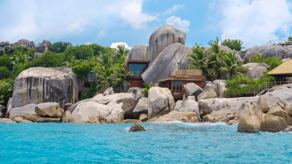 Villas among granite boulders above turquoise water