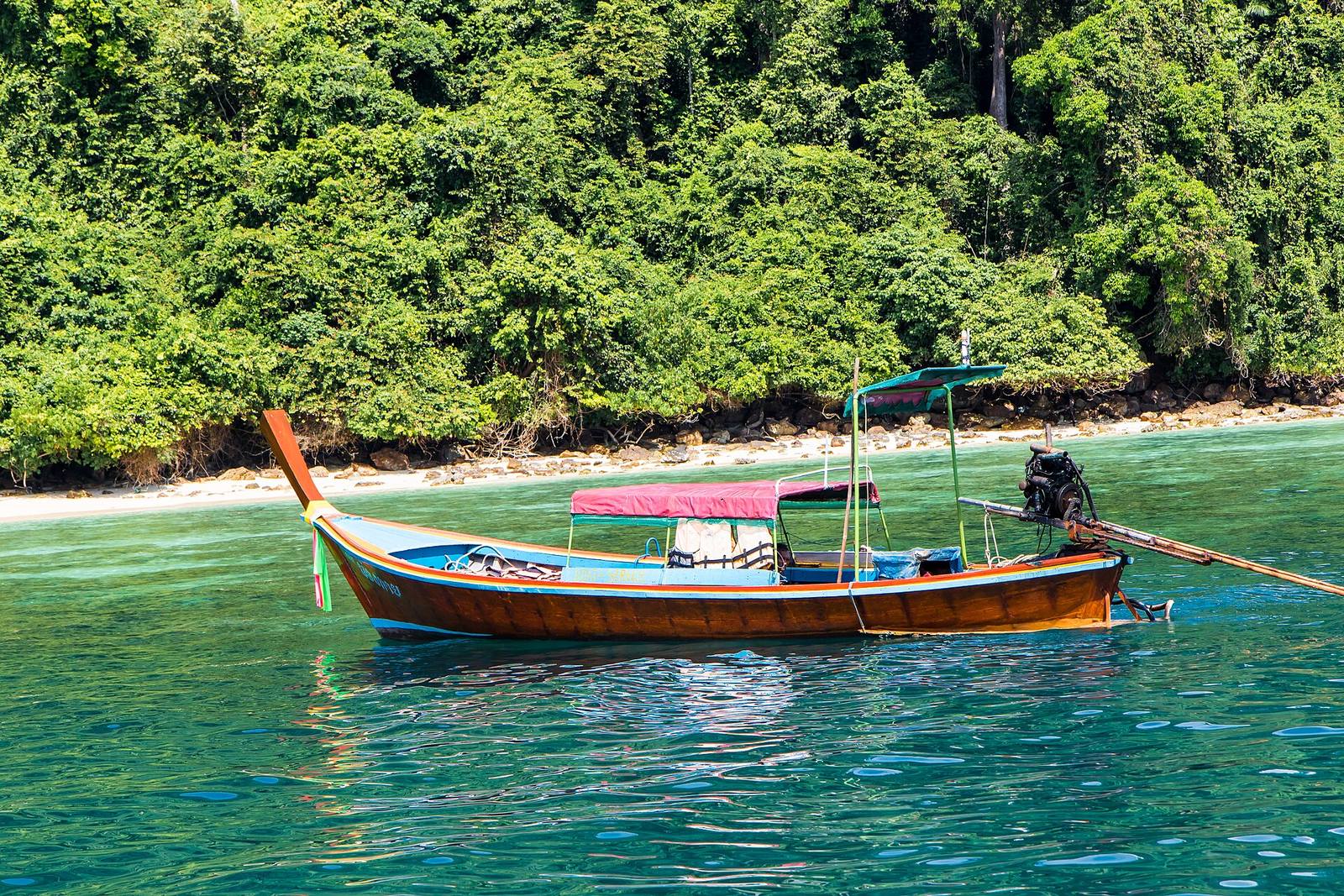 Traditional longtail boat moored in turquoise water in Thailand