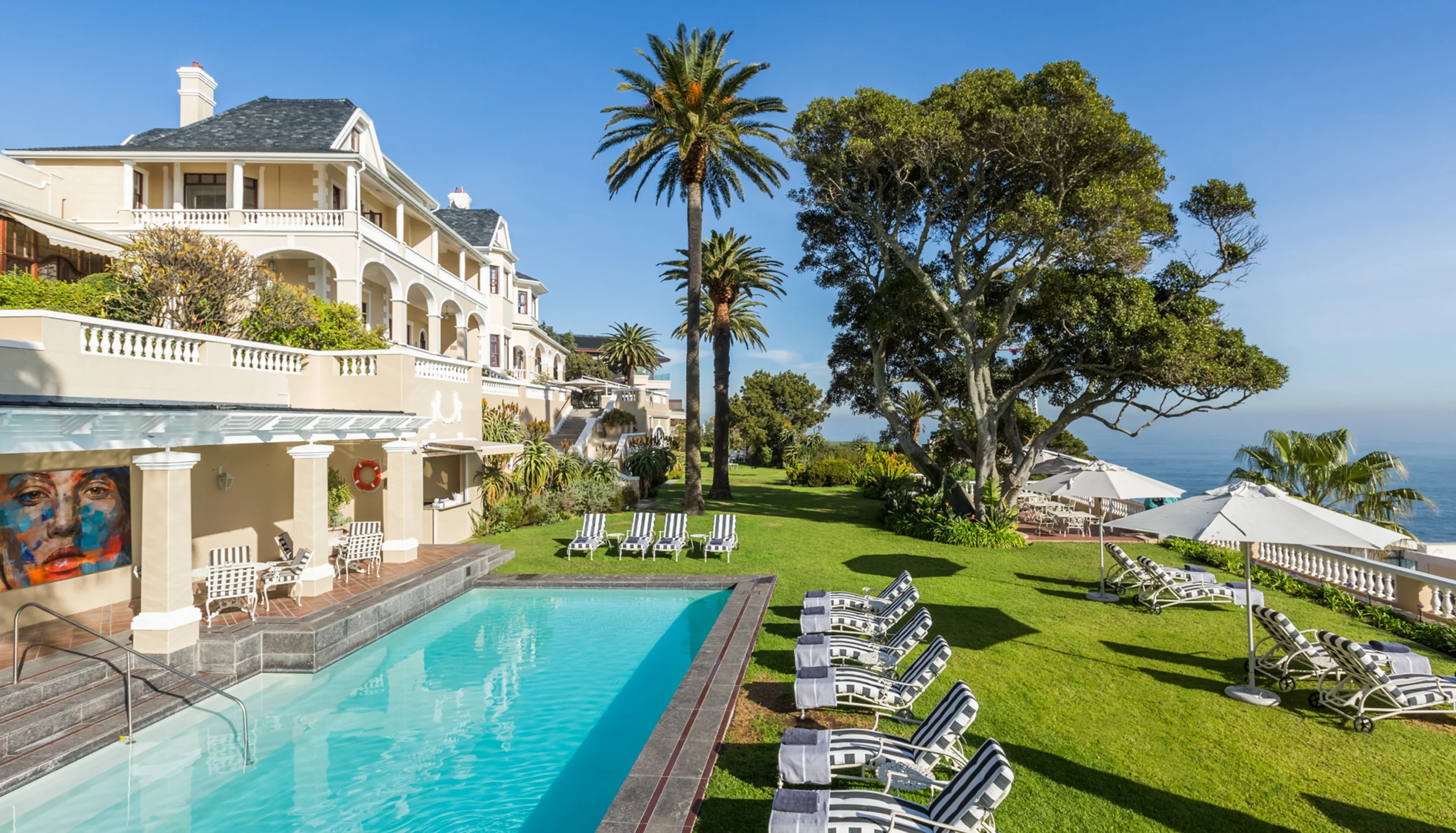 Hillside mansion with a pool and lawn above the sea