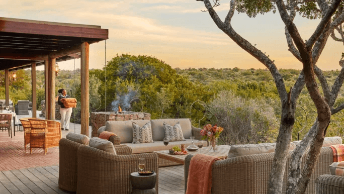 Lodge deck with sofas overlooking the bush at sunset