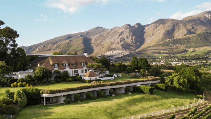 Country hotel above rolling farmland below mountains