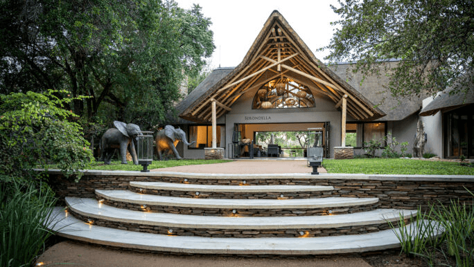 Thatched lodge entrance at the top of curved stone steps