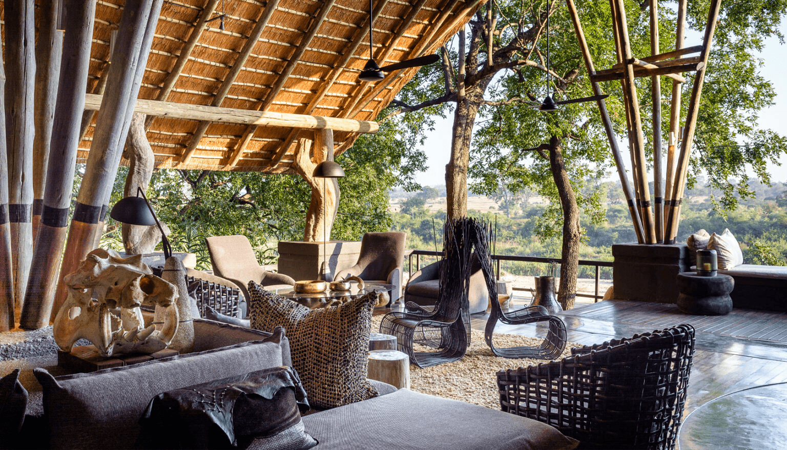 Lodge lounge with sculptures under a thatched roof