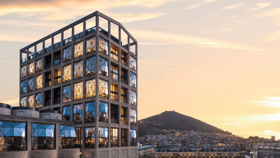 Converted grain silo with faceted glass windows at sunset