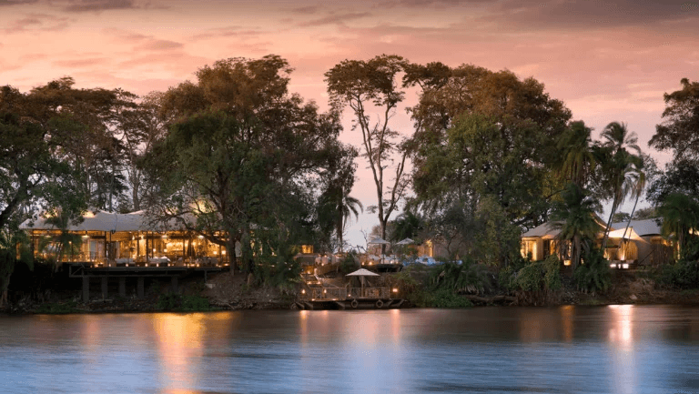Riverside lodge lit up at dusk