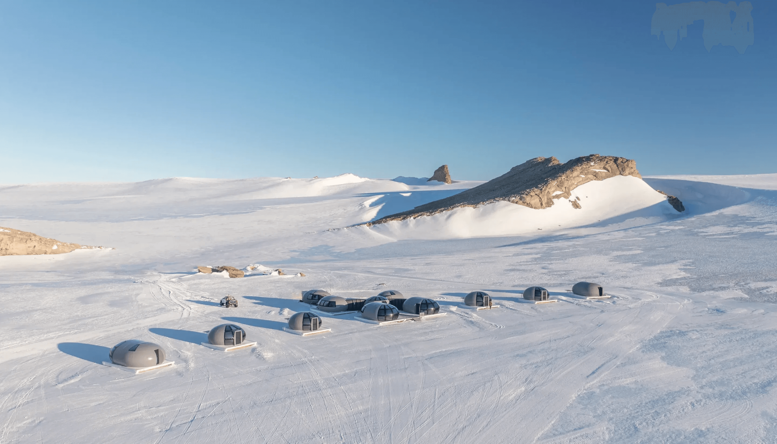 Pod-shaped tents on Antarctic ice below a rock ridge