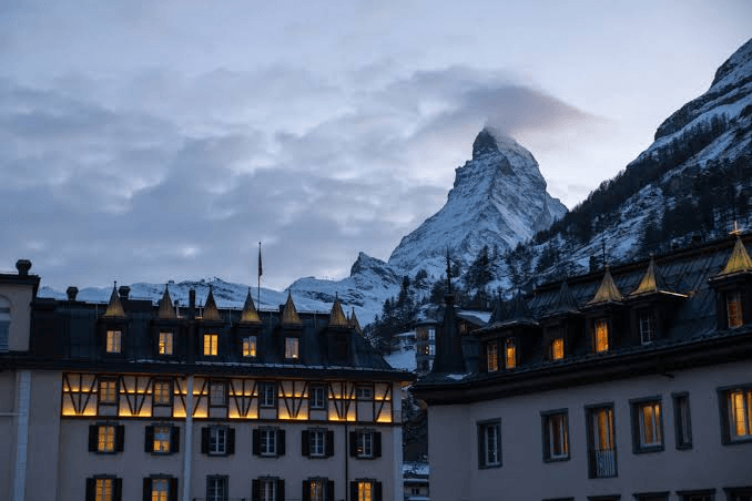 Hotel rooftops lit at dusk below the Matterhorn