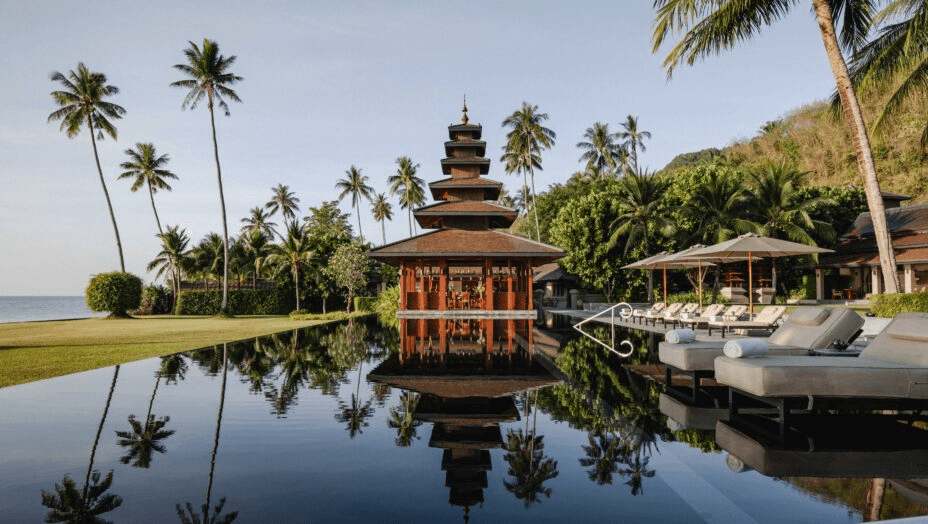 Thai pagoda reflected in an infinity pool by the sea