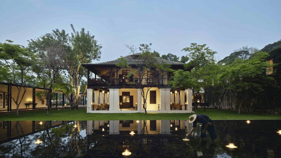 Colonial-style house reflected in a dark pool