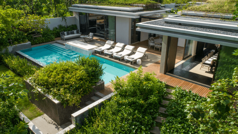 Pool villa with a planted roof among tropical gardens