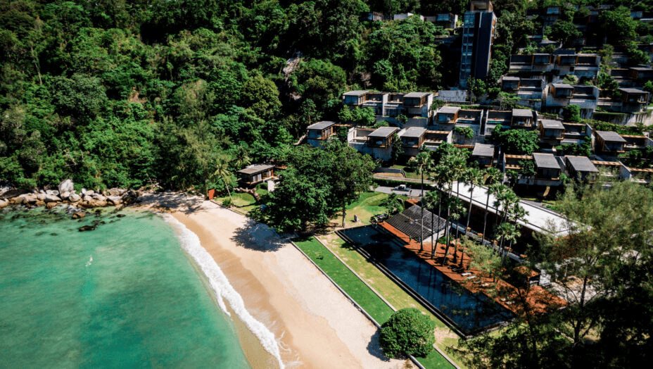 Hillside villas above a small beach, seen from the air