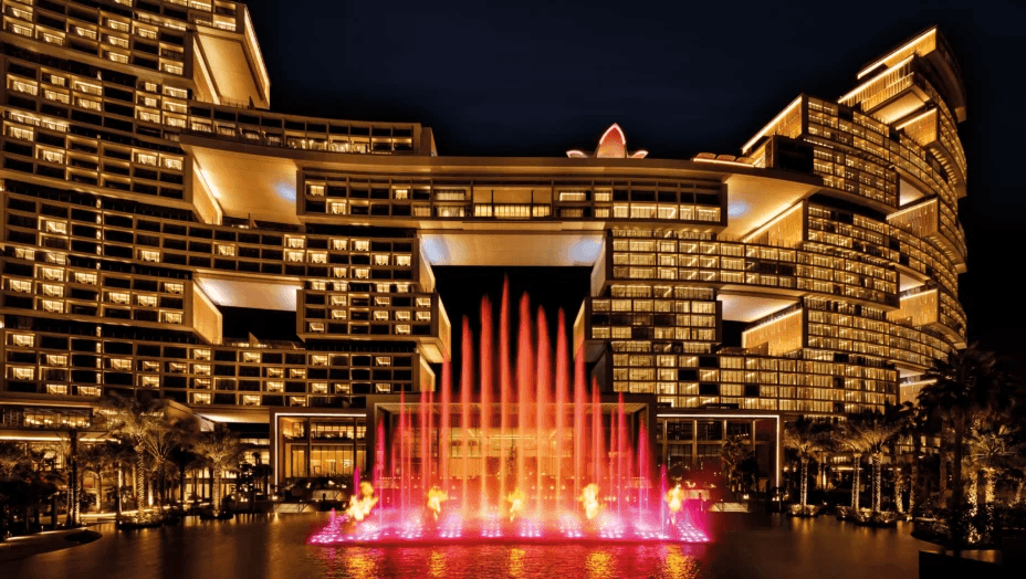 Palm-lined resort pool lit up at night