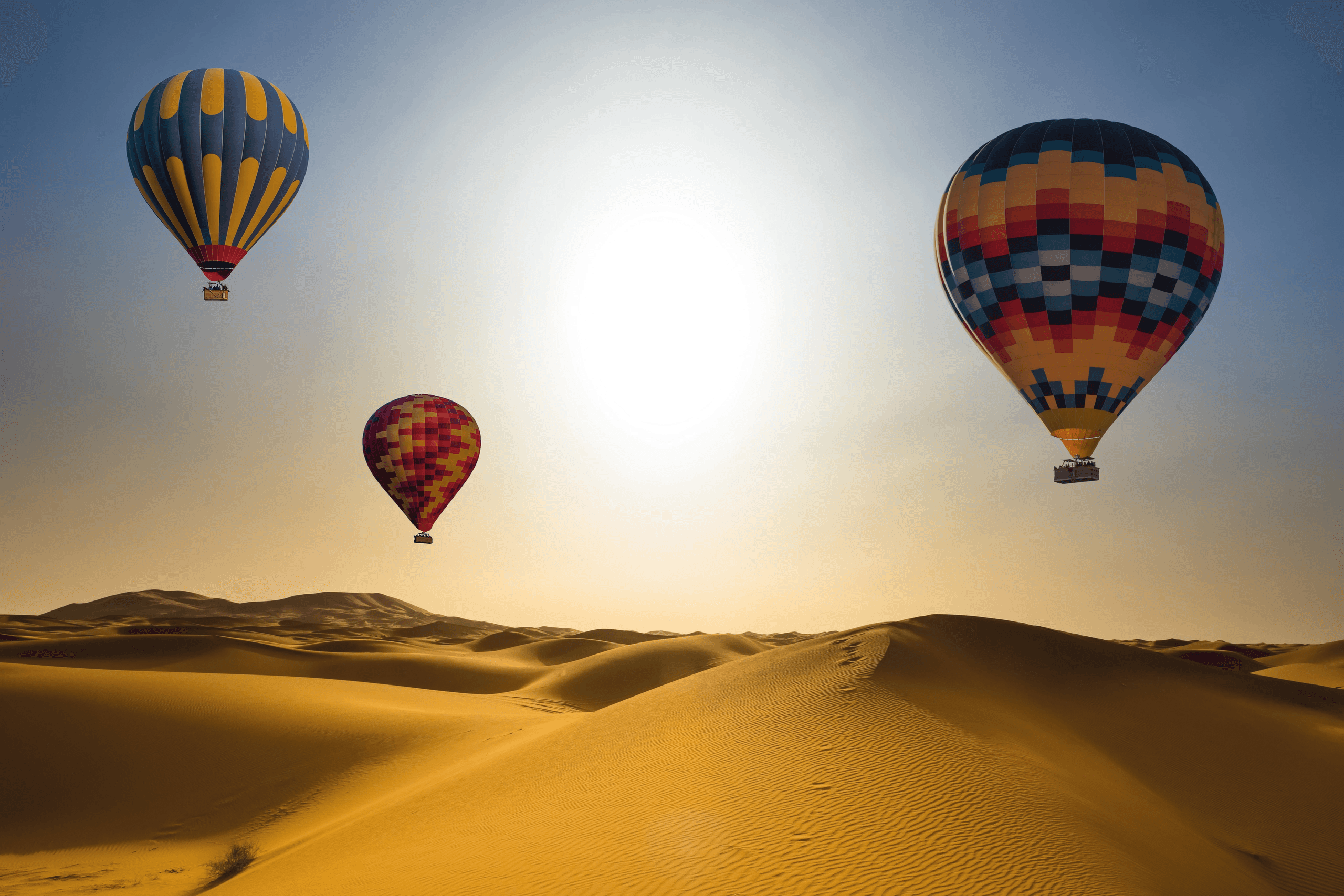 Hot-air balloons drifting over the desert at dawn