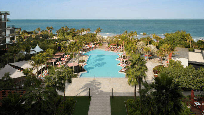 Palm-lined pool leading down towards the sea