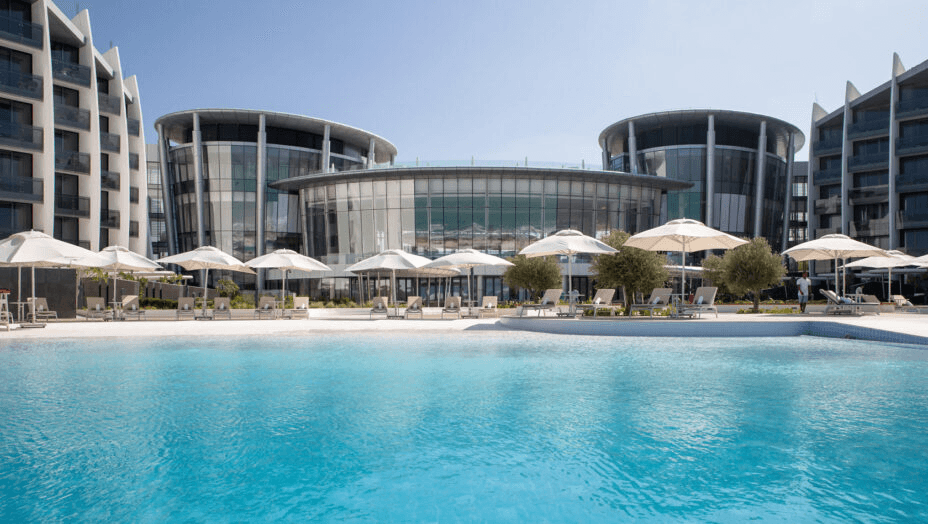 Pool and parasols in front of a modern resort building