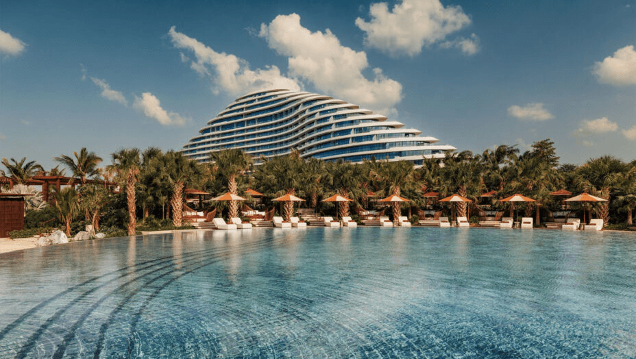 Infinity pool facing a curved, terraced hotel building